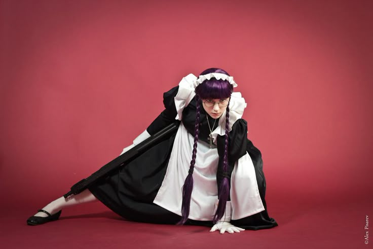 a woman dressed in black and white sitting on the ground with her hands behind her head