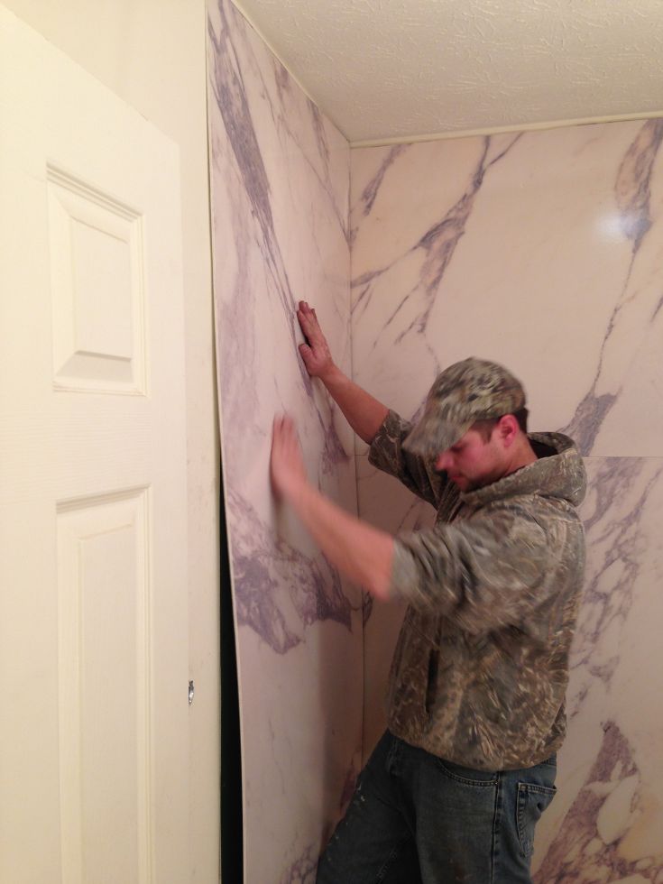 a man is painting the walls in his house with marble paint and white trim on it