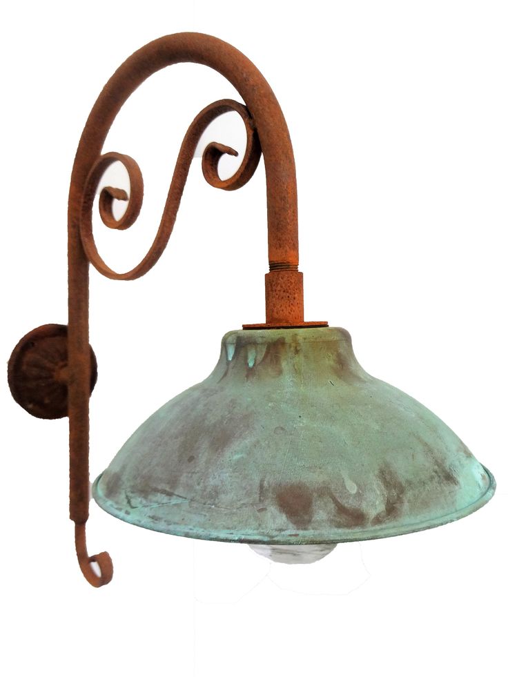 an old - fashioned wall light with a green glass shade hanging from it's side