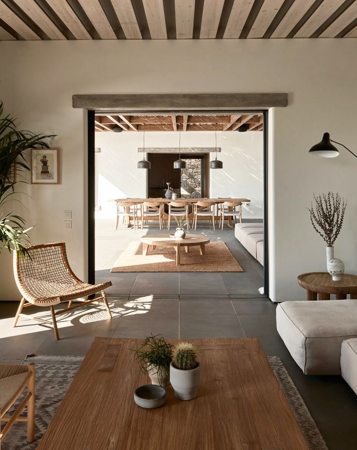 a living room filled with furniture next to a wooden table and planter on top of a hard wood floor