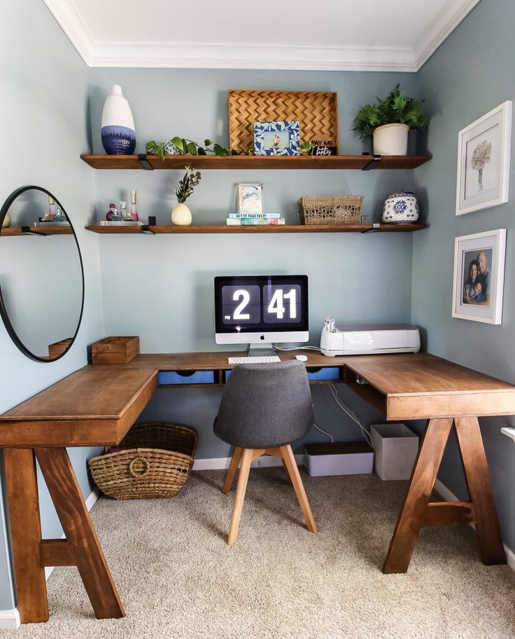 a desk with a computer on top of it in front of a mirror and shelves