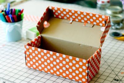 an open box sitting on top of a table with markers and pencils in it