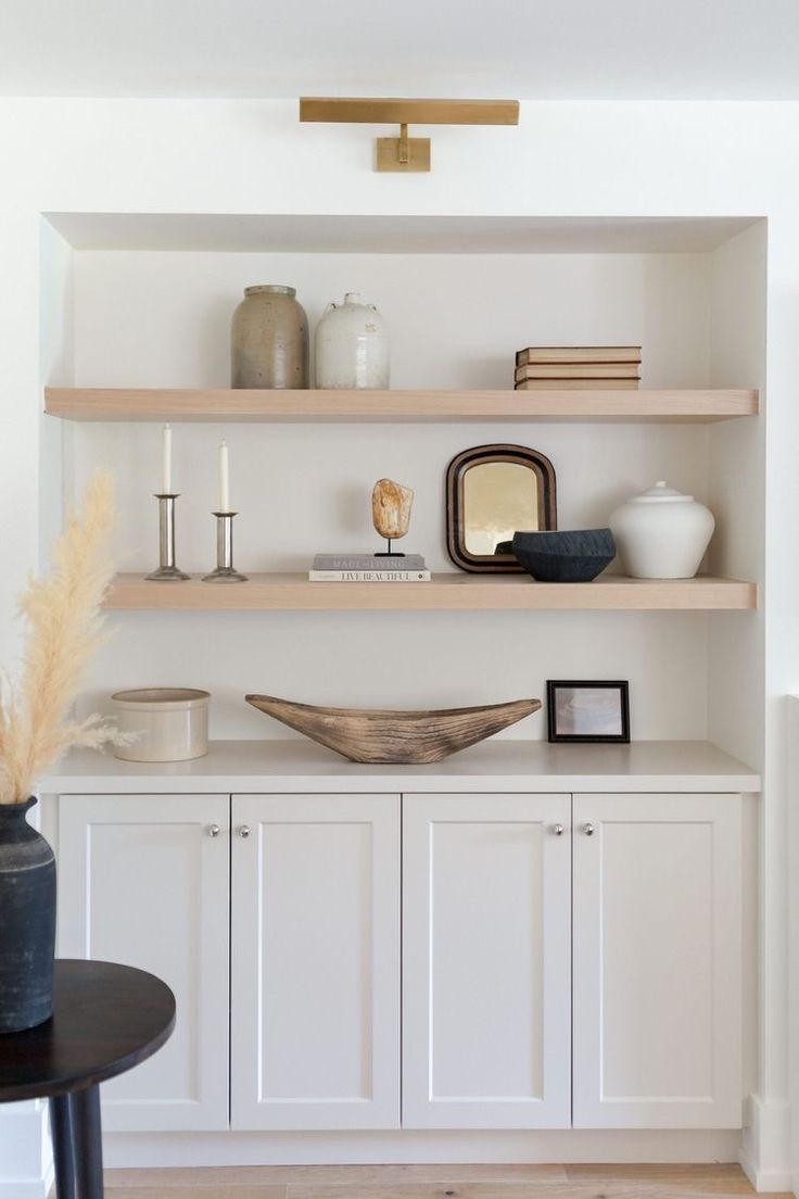 the shelves in this living room are filled with vases and other decorative items on them