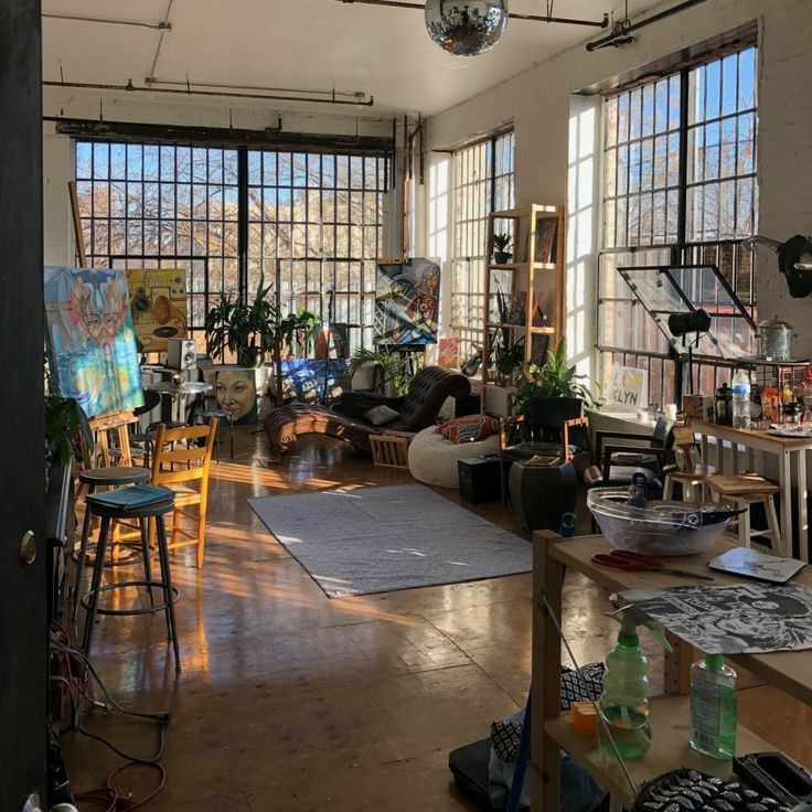 a living room filled with furniture and lots of windows next to a painting on the wall