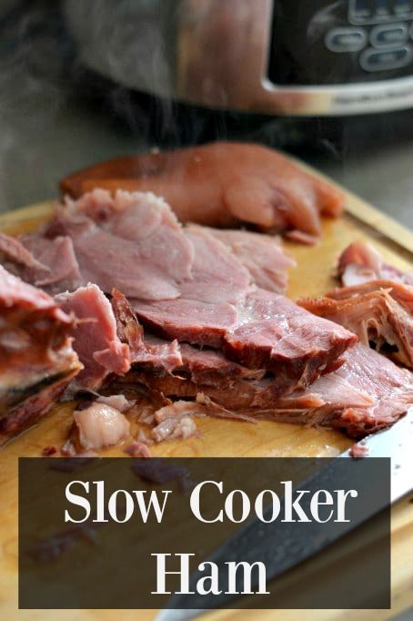 slow cooker ham on a cutting board with the words slow cooker ham over it