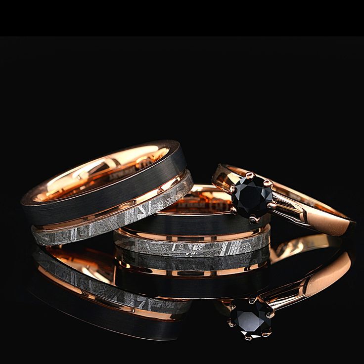 three different types of wedding rings with black diamonds on them and gold bands around the edges