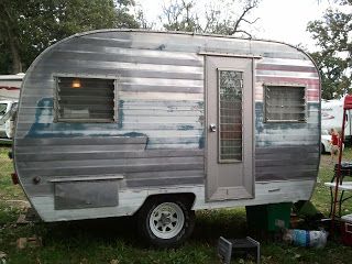 an old trailer is parked in the grass