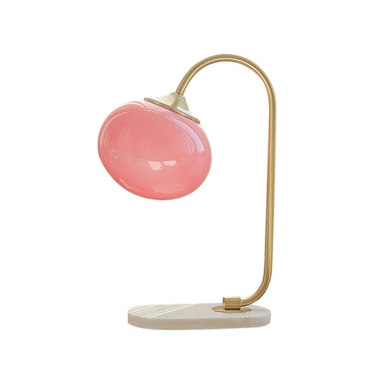 a pink lamp on a white surface with a gold metal base and a marble base