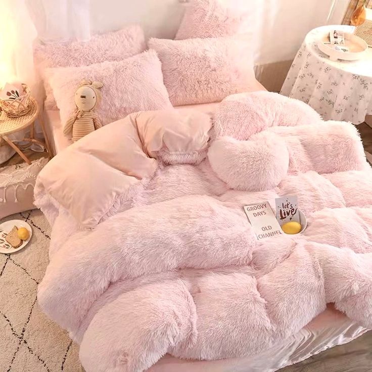 a bed with pink comforters and pillows in a child's bedroom, next to a teddy bear