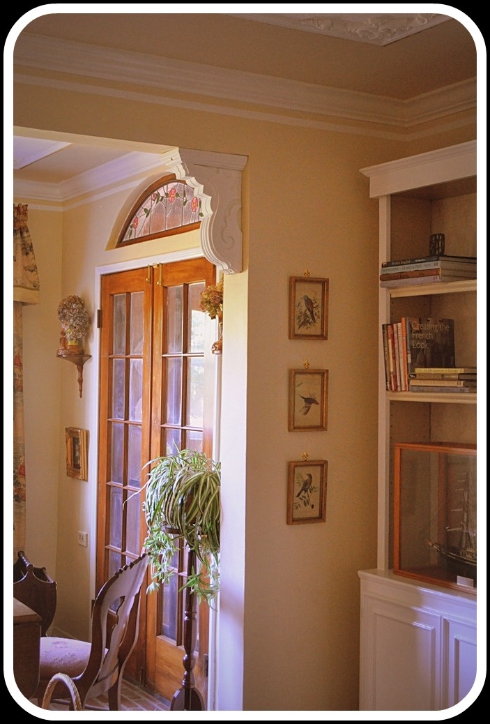 a living room filled with furniture next to a tall book shelf covered in books and plants