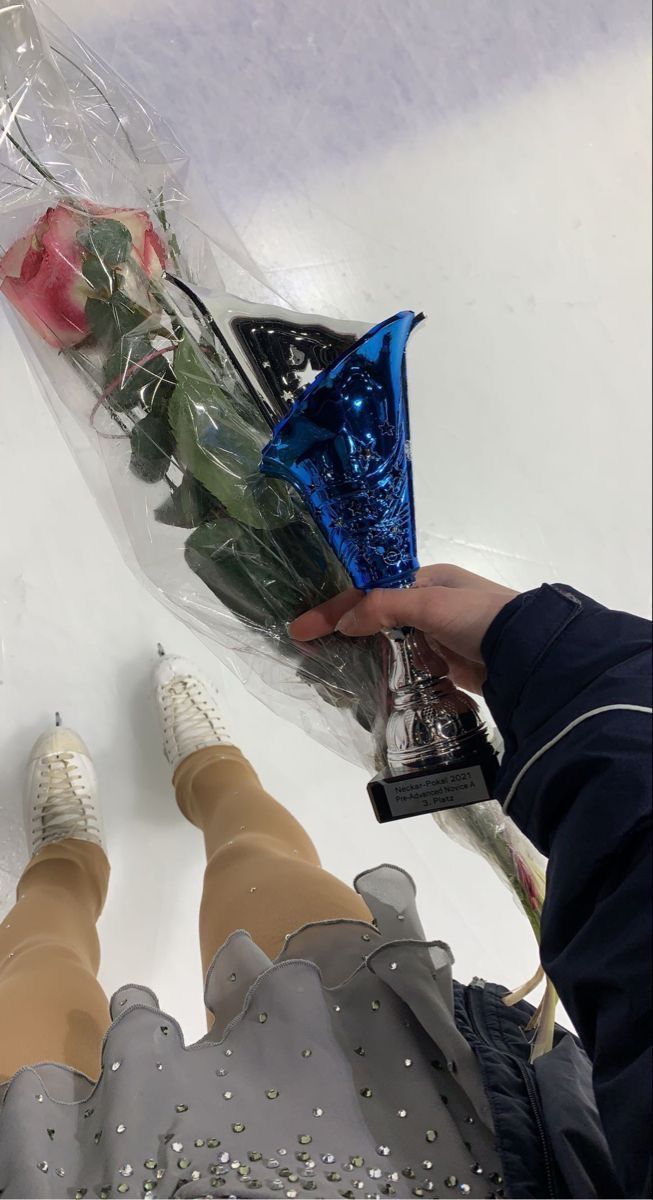 someone is holding flowers in front of their legs