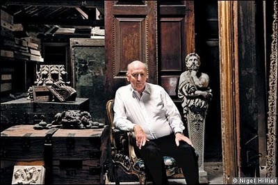 a man sitting in a chair next to some statues