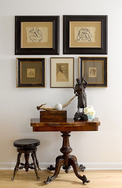 a table with two stools and pictures on the wall