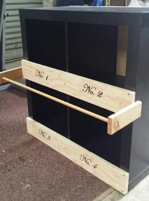 two wooden drawers with numbers on them sitting in front of a metal box and door