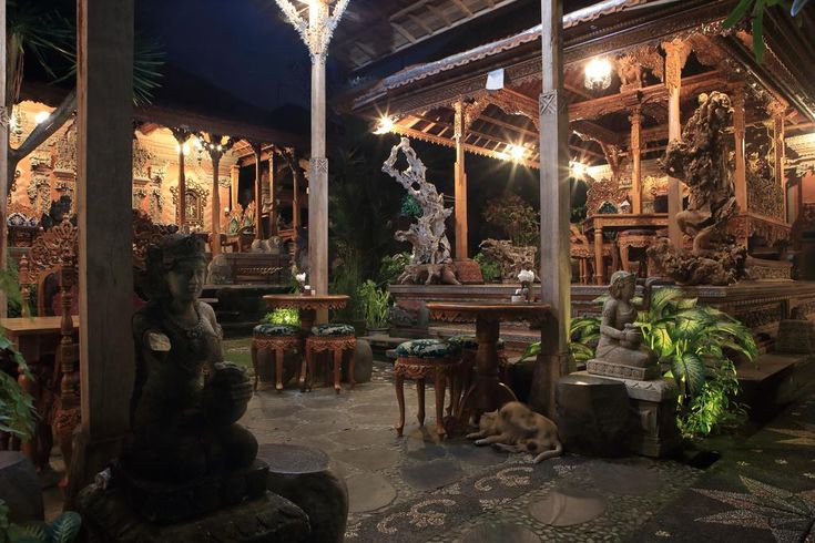 an outdoor area with statues and tables at night