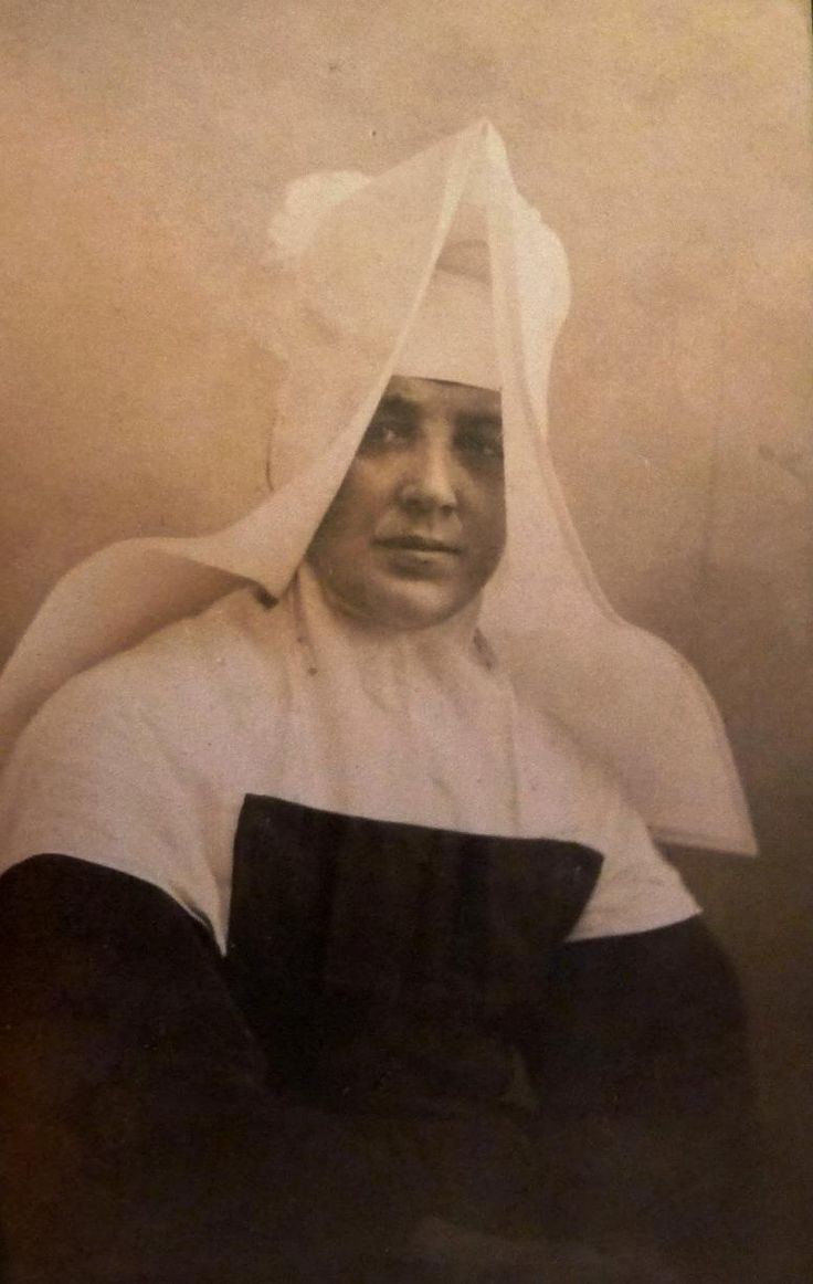 an old black and white photo of a woman with a veil on her head,