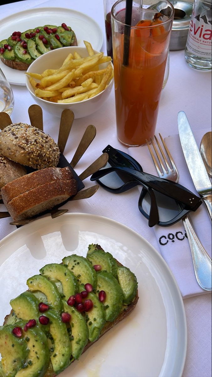 a table topped with plates and glasses filled with food next to utensils on top of a white table cloth