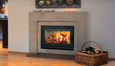 a living room with a fire place in the center and a basket on the floor