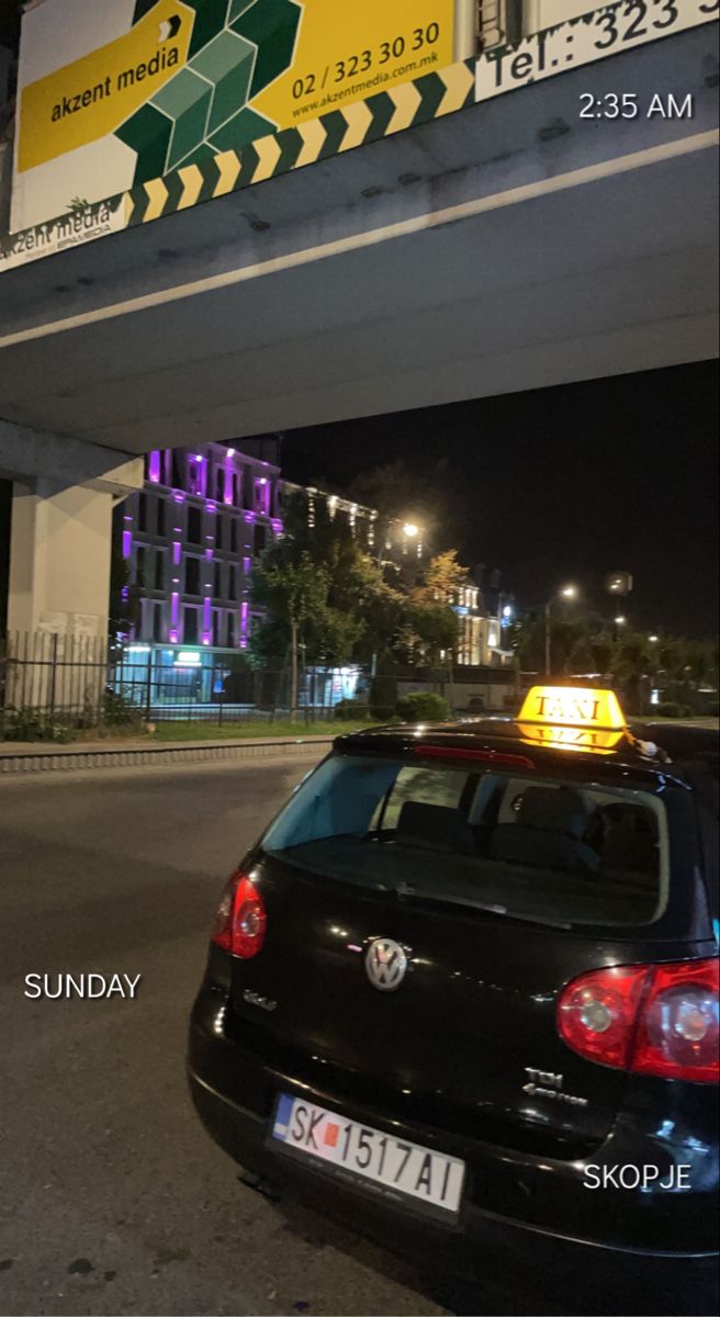 a car parked under an overpass with a yellow light on it's roof