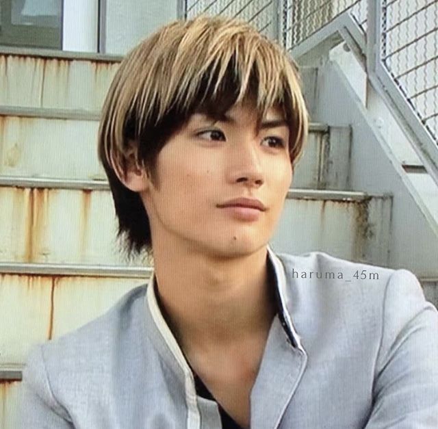 a young man sitting in front of some stairs