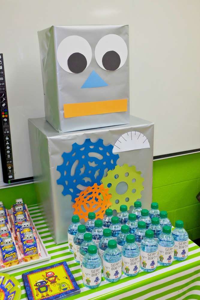 a robot made out of soda bottles on top of a green and white table cloth