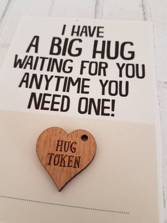 a wooden heart shaped pin with the words hug token written on it and a card that says, i have a big hug waiting for you anytime you need one