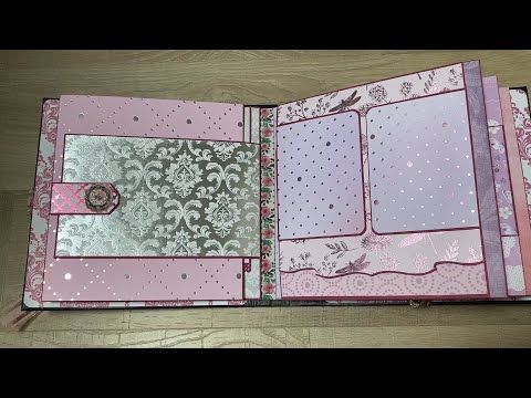 an open pink and silver book on a wooden table