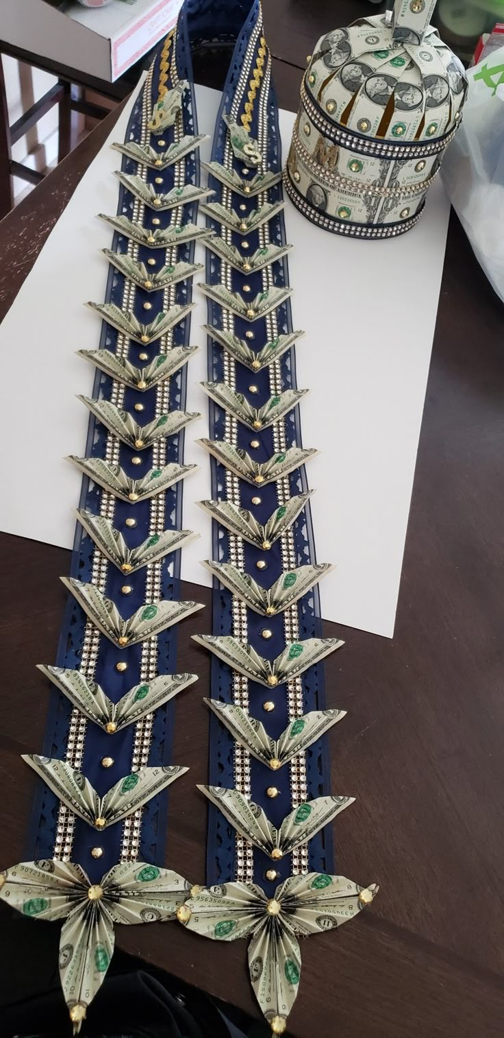 a pair of blue and gold belts sitting on top of a table next to money