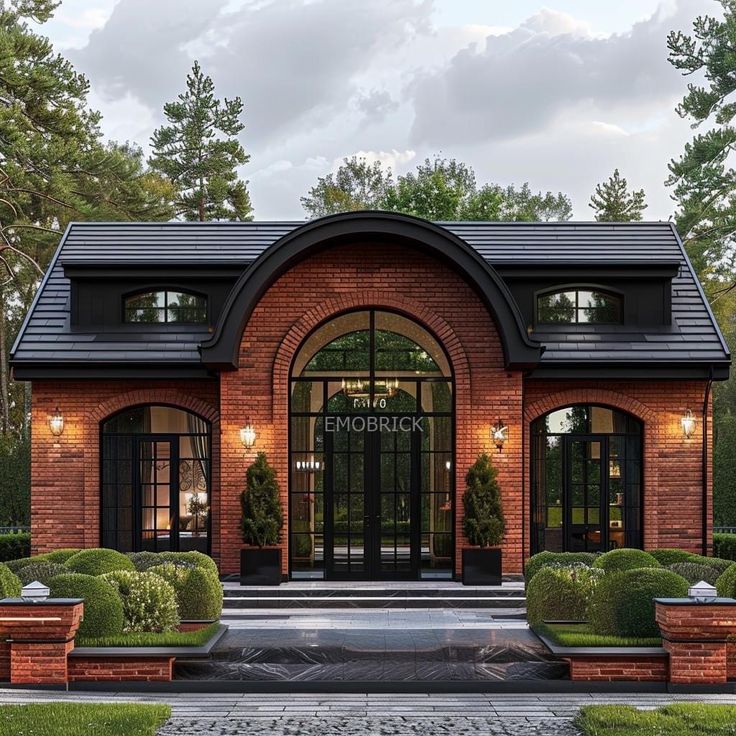 a brick building with two large windows and lots of potted plants in the front