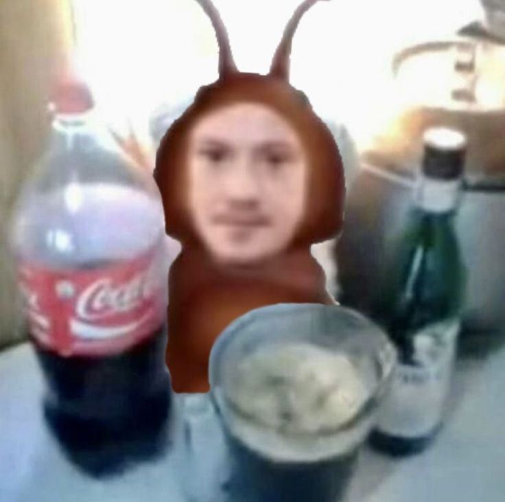 a blurry photo of a man with an animal head next to some soda bottles