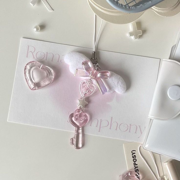 a pink key is attached to a card with a bow and heart shaped keychain