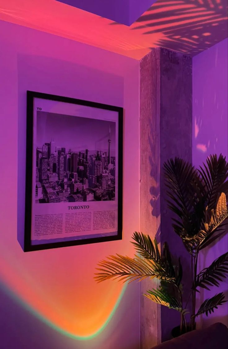 a plant in a pot sitting next to a wall with a purple light on it