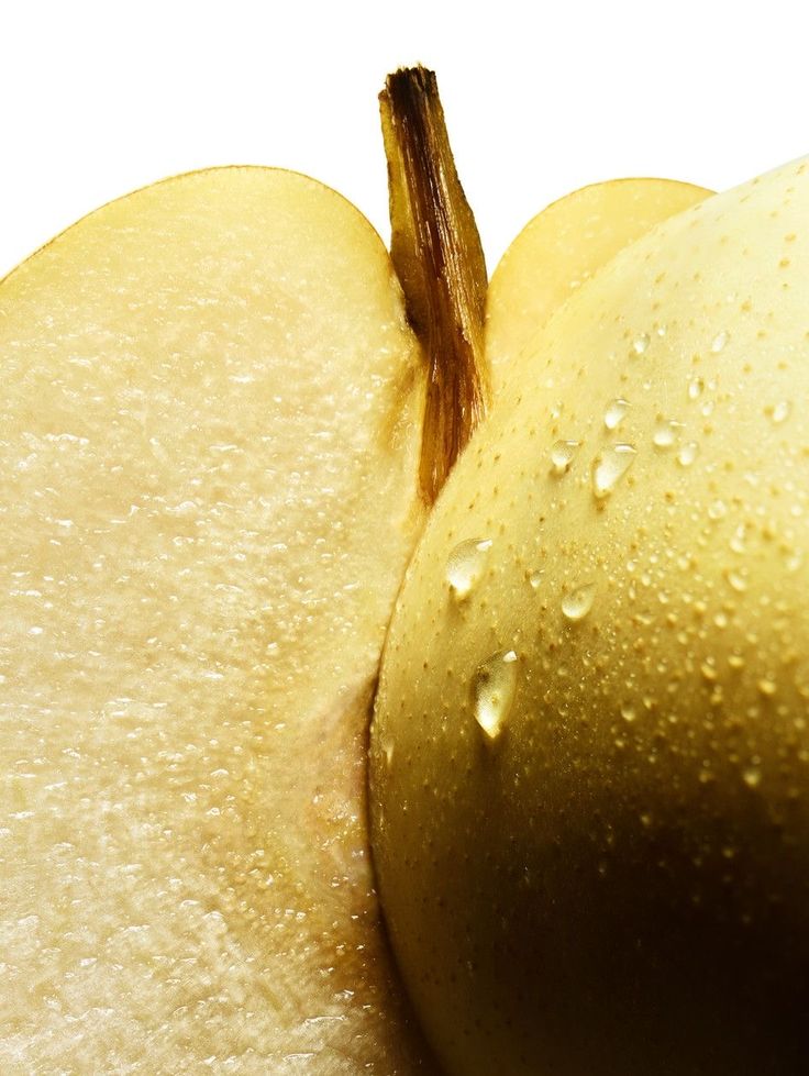 an apple that has been sliced in half with water droplets on the top and bottom