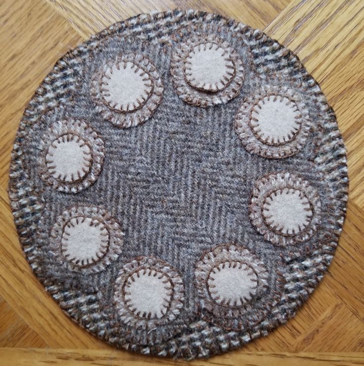 a close up of a rug on a wooden floor with many circles in the middle