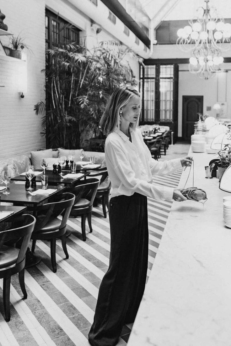 a woman standing at the bar in a restaurant