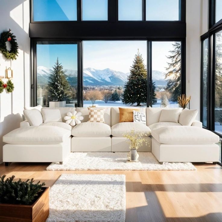 a living room filled with white furniture and large windows overlooking the snow covered mountain range