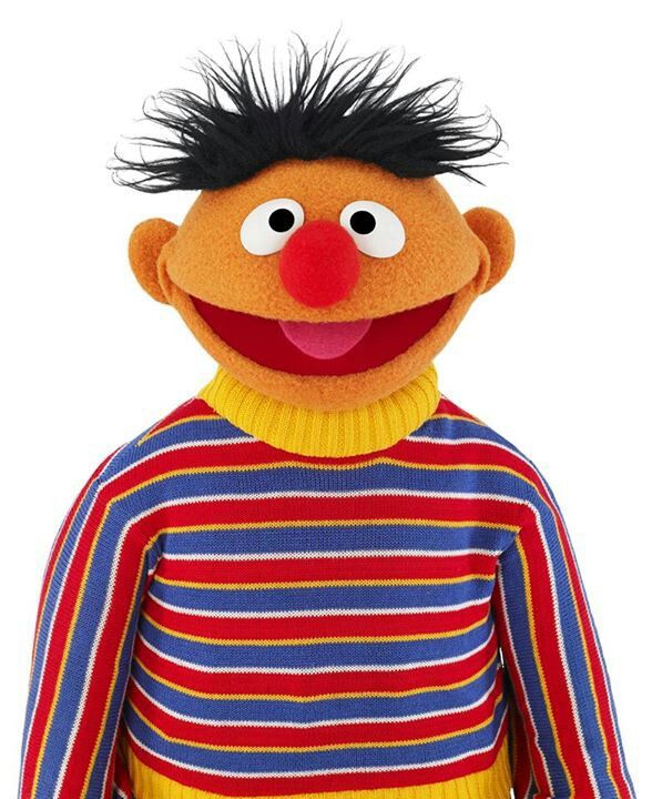 the puppet is wearing a striped shirt and standing in front of grass with his hair up