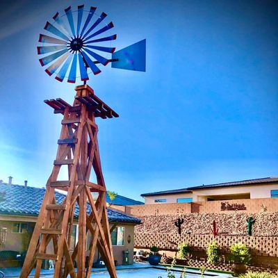 an old wooden windmill sitting in the middle of a yard