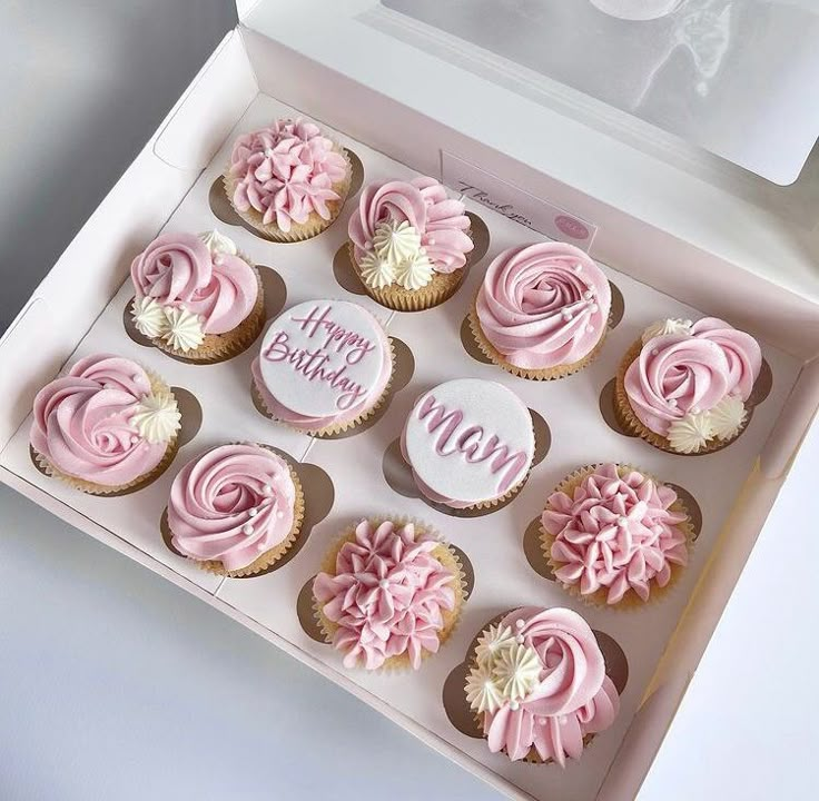 a box filled with pink cupcakes sitting on top of a table