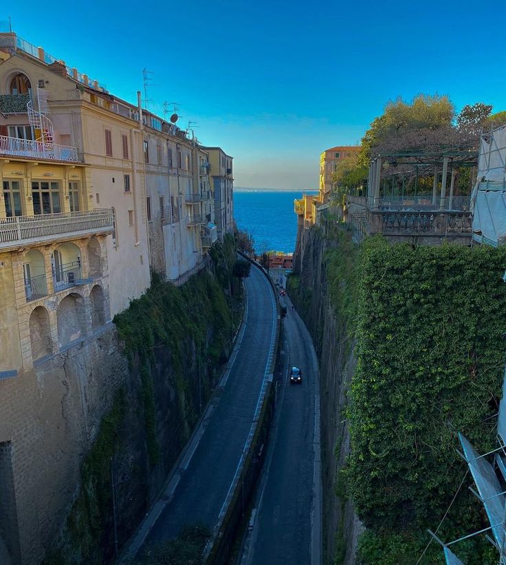 an aerial view of a street with cars driving down the road next to some buildings