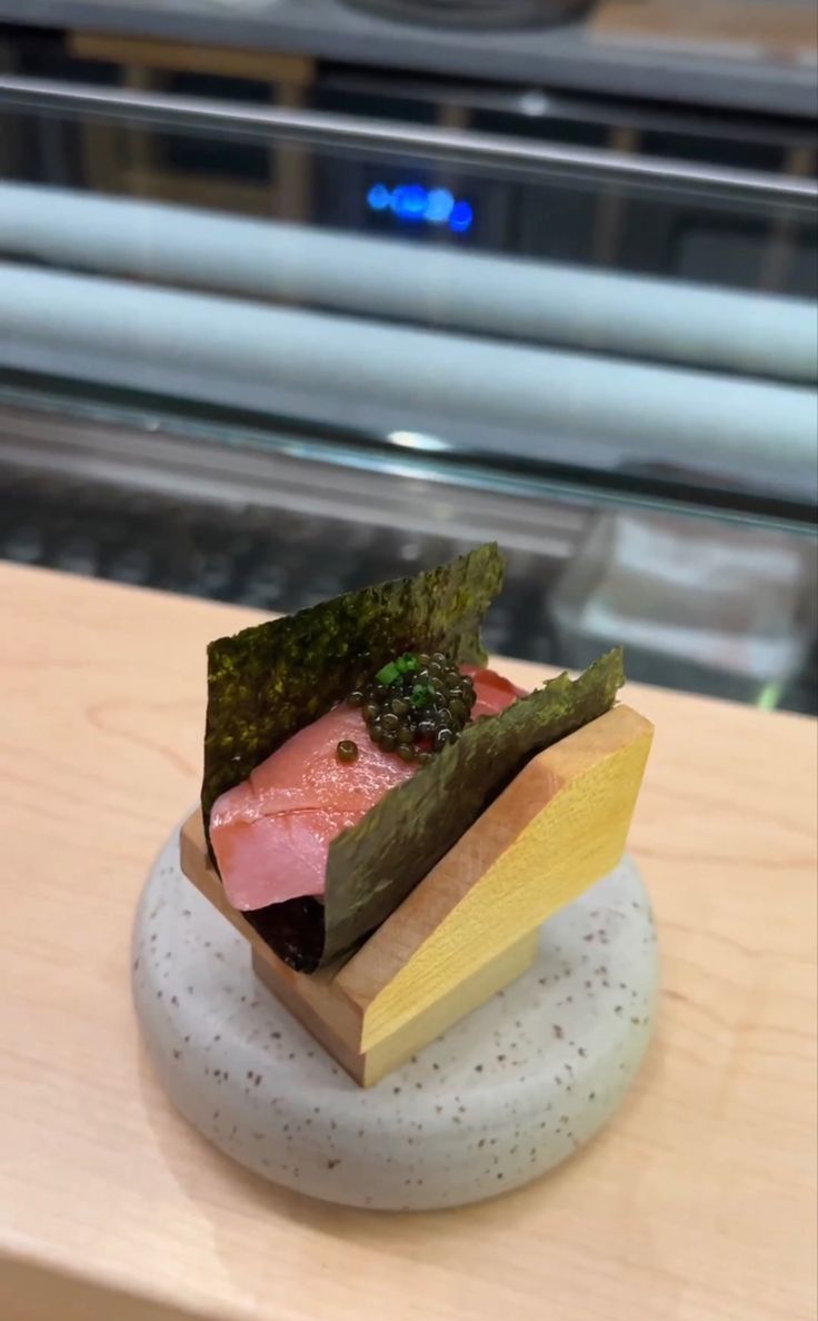 a plate with some food on it sitting on top of a wooden table next to a glass case