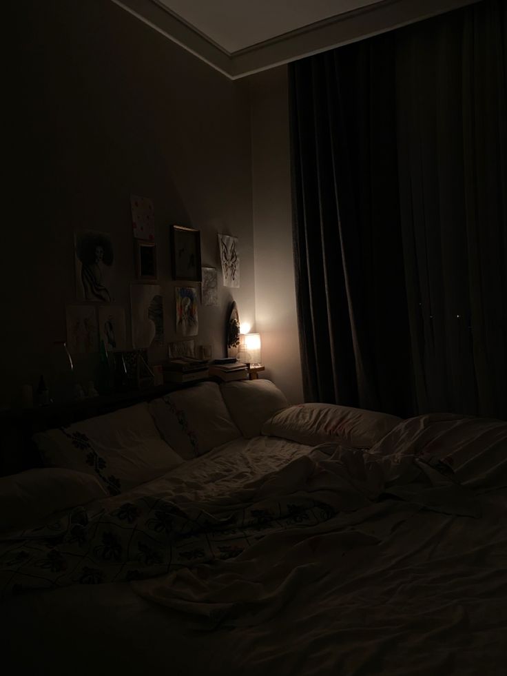 an unmade bed in a dimly lit room