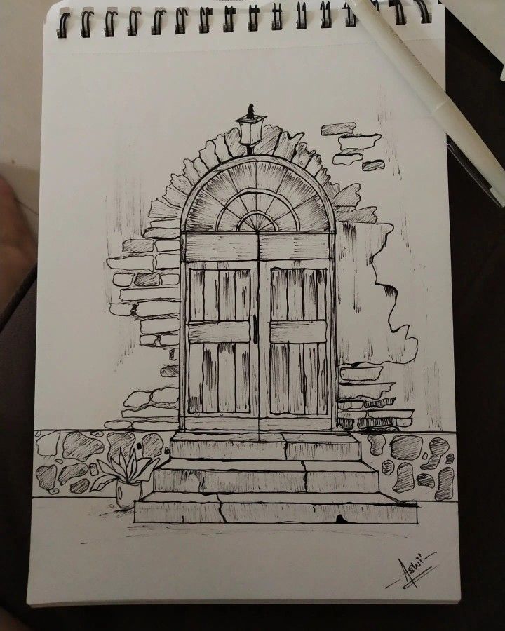 a drawing of an open door on a piece of paper with a pen next to it