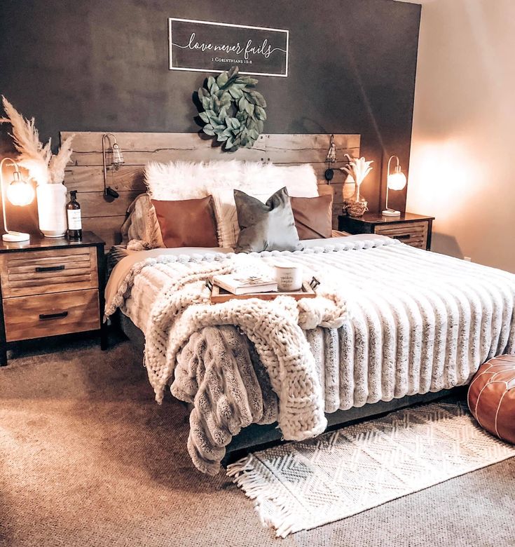 a bedroom with a bed, nightstands and pillows on the floor in front of a chalkboard wall