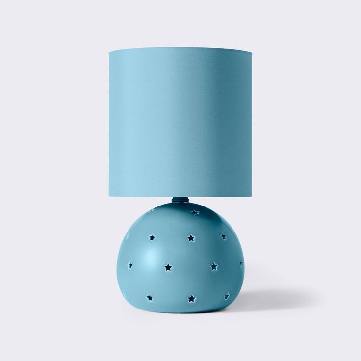 a blue lamp with stars on the base and a light blue shade over it's top