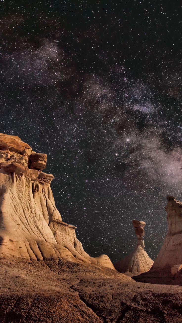 the stars shine brightly in the night sky above some desert formations and rock formations,