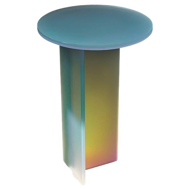 a round table with a blue top and rainbow colored glass on the bottom, against a white background