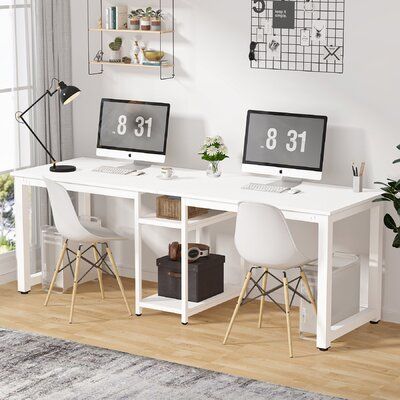 two computer monitors sitting on top of a white desk in front of a large window