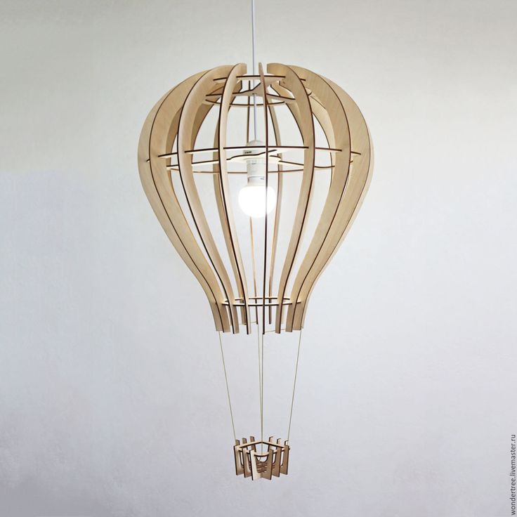 a light fixture made out of wood and string hanging from it's side on a white wall