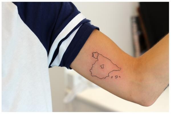 a person's arm with a small map tattoo on the left side of their arm